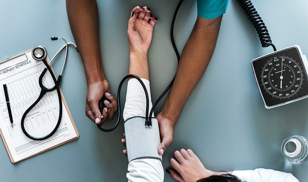 A healthcare professional performing blood pressure monitoring on a patient