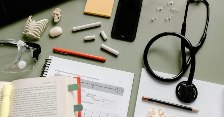 A book, loose papers and a stethoscope on a desk