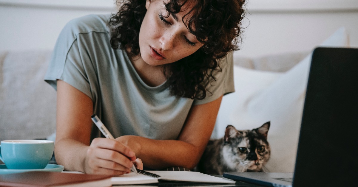 Girl studying in the company of her cat