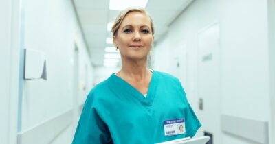 Going to nursing school at 30 header Mature nurse standing in hospital hallway