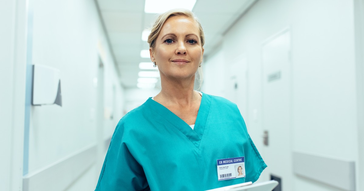 Mature nurse standing in hospital hallway