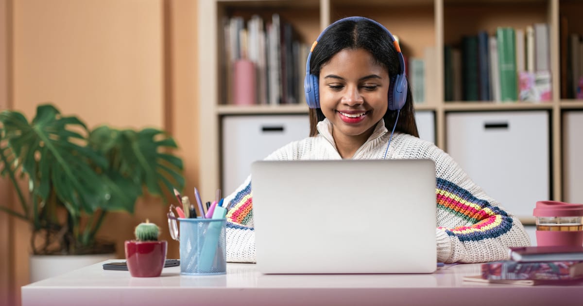 Teenager African American Female Student studying and working at home with laptop