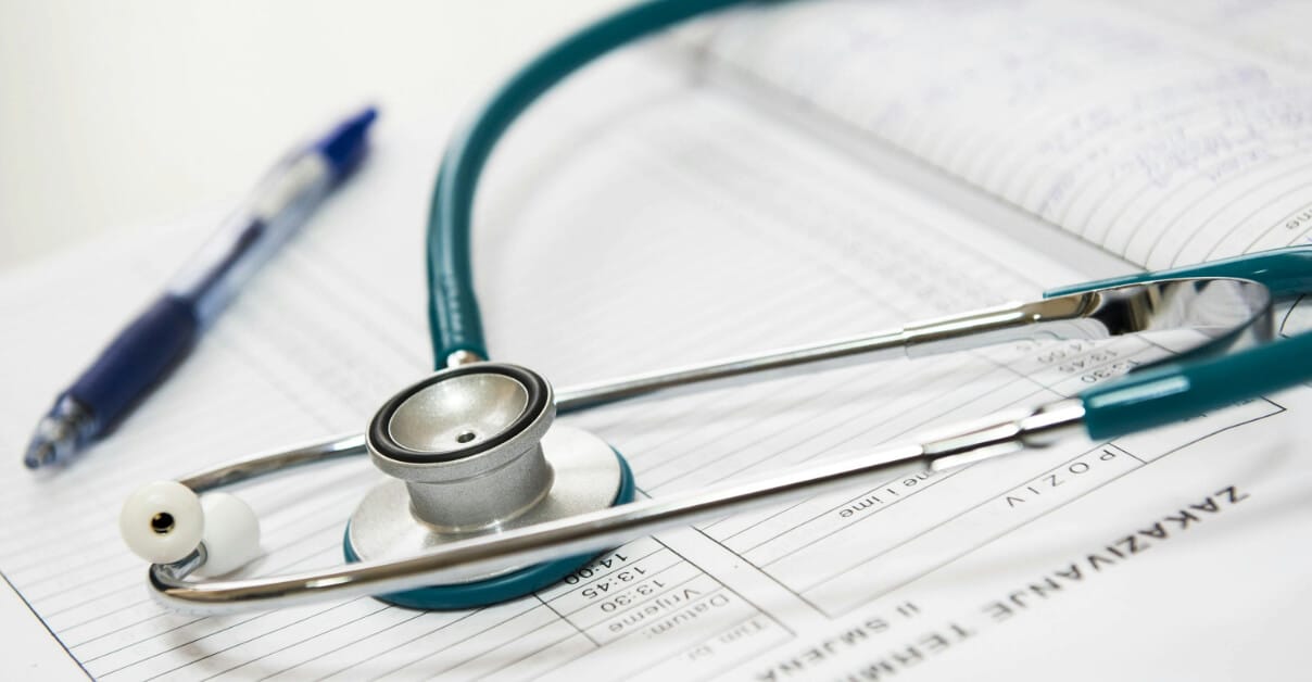 A stethoscope and a pen lying on a paper form