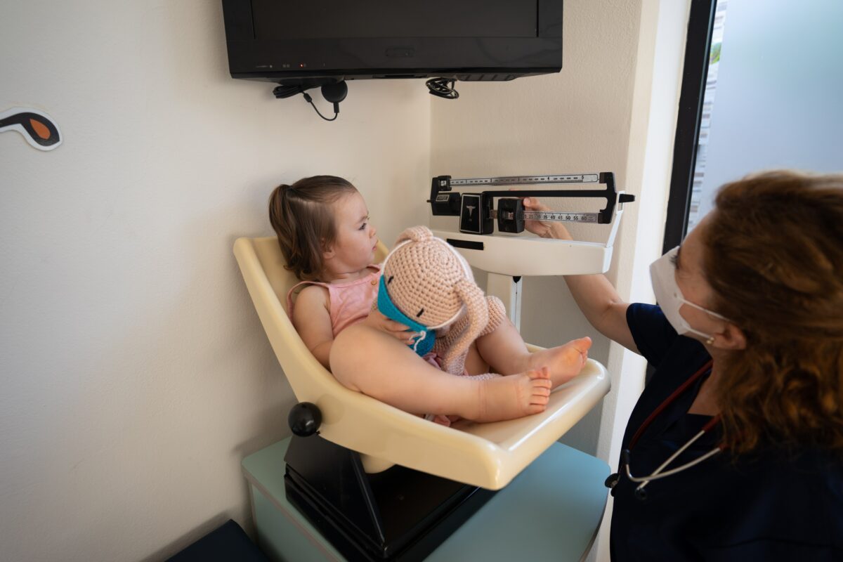 Pediatrician weighing child