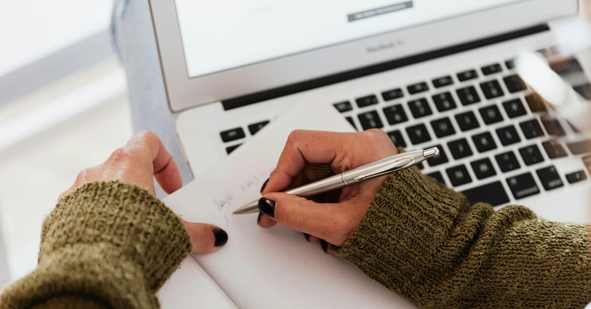 Usmle changes 2026 blog banner Person taking notes on paper while sitting behind a laptop