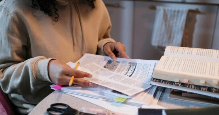 Person studying at desk full of study materials