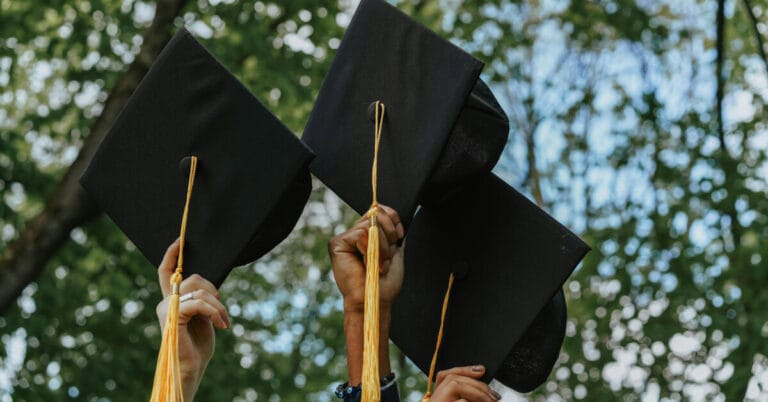 Students holding up their graduation caps