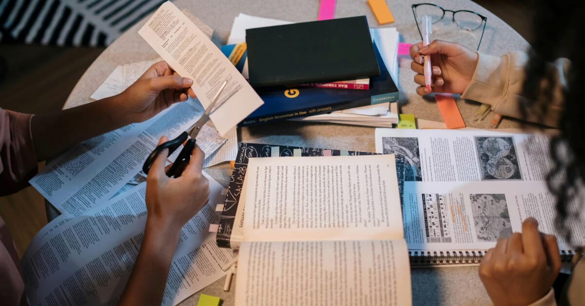 Person studying at desk filled with study materials