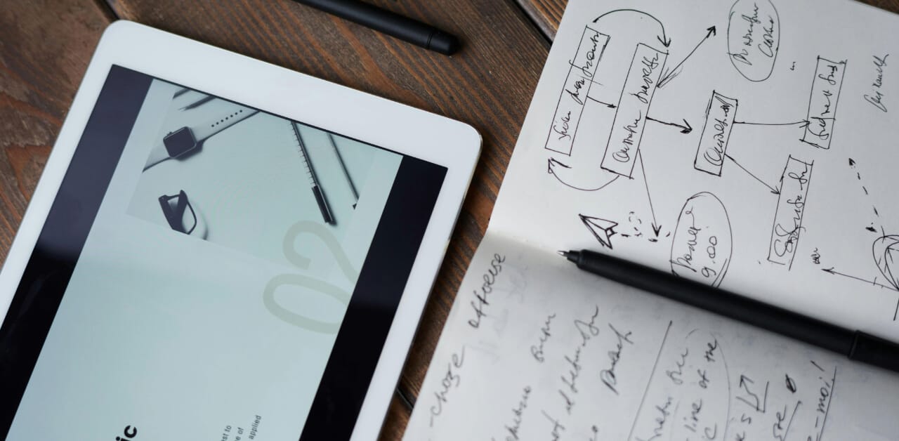 Picture of person studying on a tablet and taking notes - best mcat prep books
