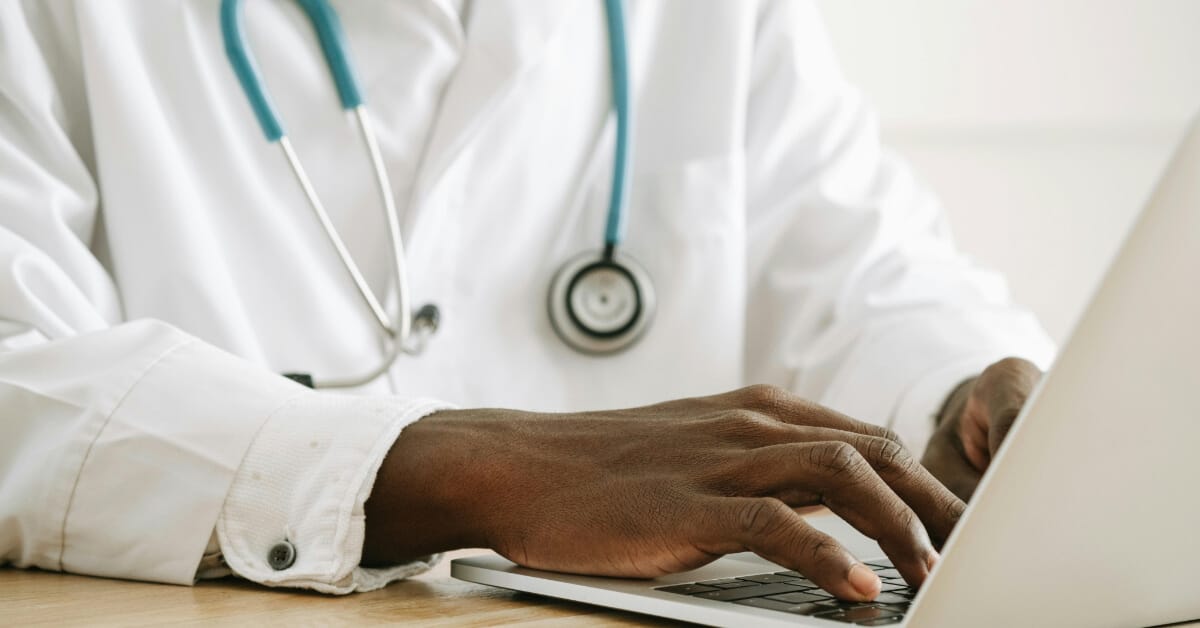 Doctor typing on their laptop