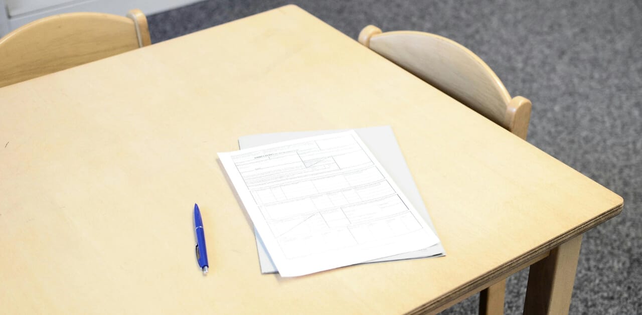 Two sheets of paper and a pen on a desk